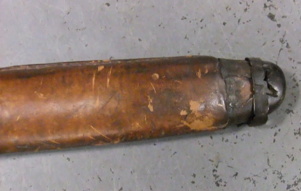 A Japanese WWII officers Shin-Gunto katana featuring a leather-wrapped scabbard, ribbed handle, and brass tsuba. View XXV