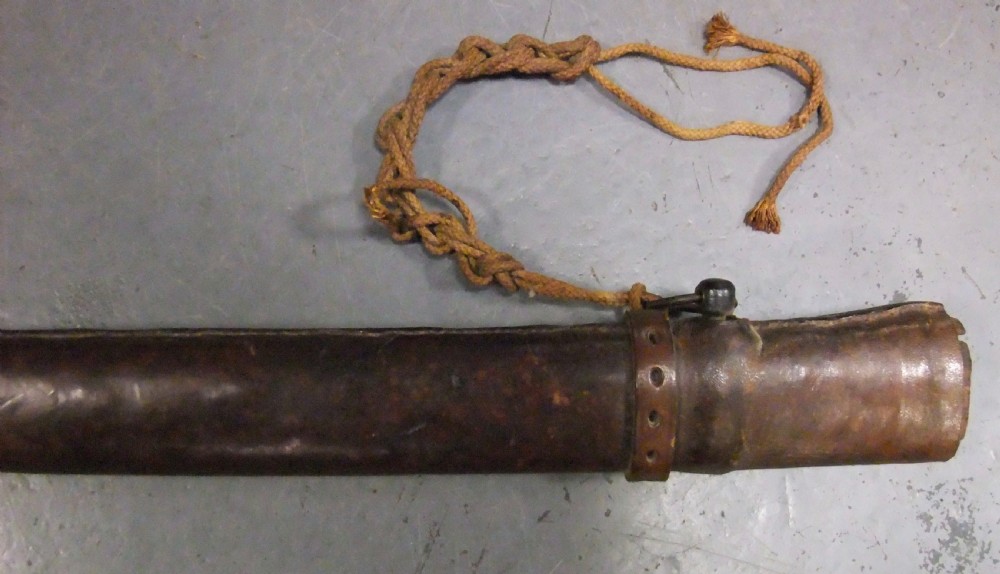 A Japanese WWII officers Shin-Gunto katana featuring a leather-wrapped scabbard, ribbed handle, and brass tsuba. View XXVI