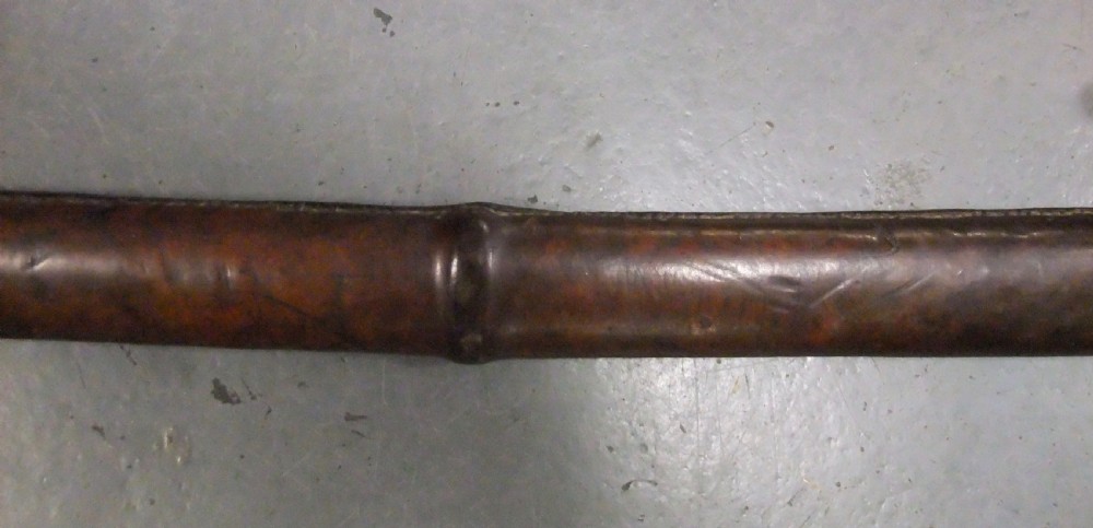 A Japanese WWII officers Shin-Gunto katana featuring a leather-wrapped scabbard, ribbed handle, and brass tsuba. View XXVII