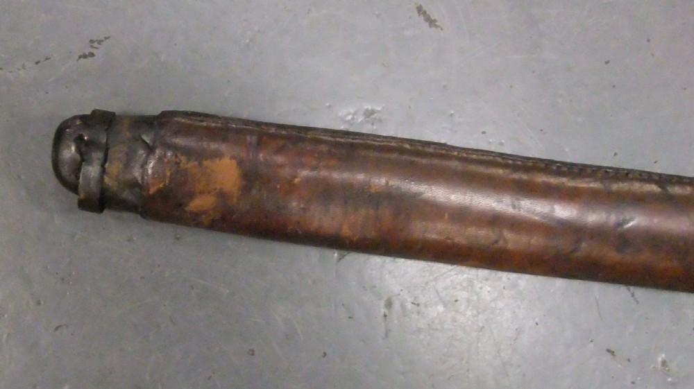 A Japanese WWII officers Shin-Gunto katana featuring a leather-wrapped scabbard, ribbed handle, and brass tsuba. View XXVIII