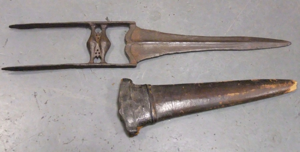 An antique Indian Katar push dagger featuring a dark iron H-shaped handle with double crossbars beside its tapered leather scabbard. View III