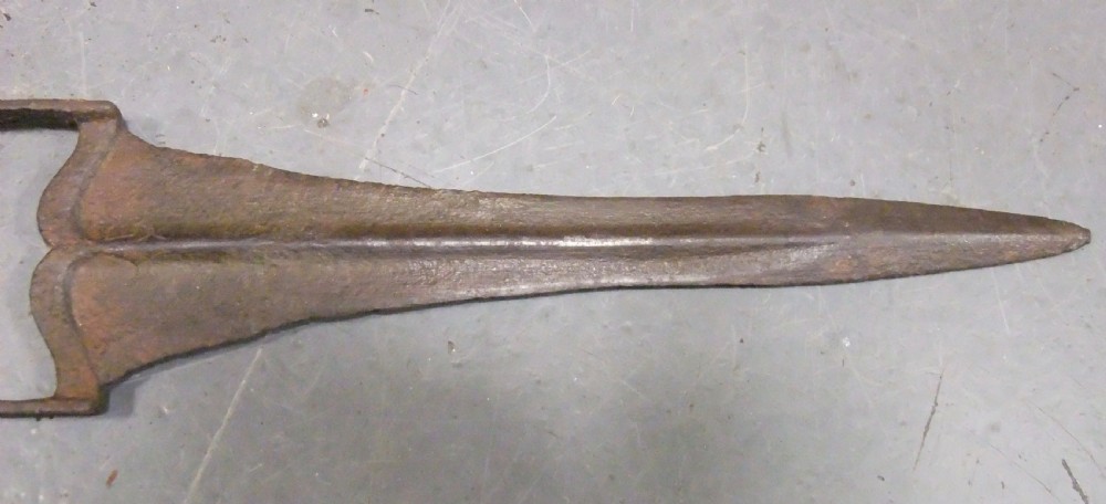 An antique Indian Katar push dagger featuring a dark iron H-shaped handle with double crossbars beside its tapered leather scabbard. View VIII