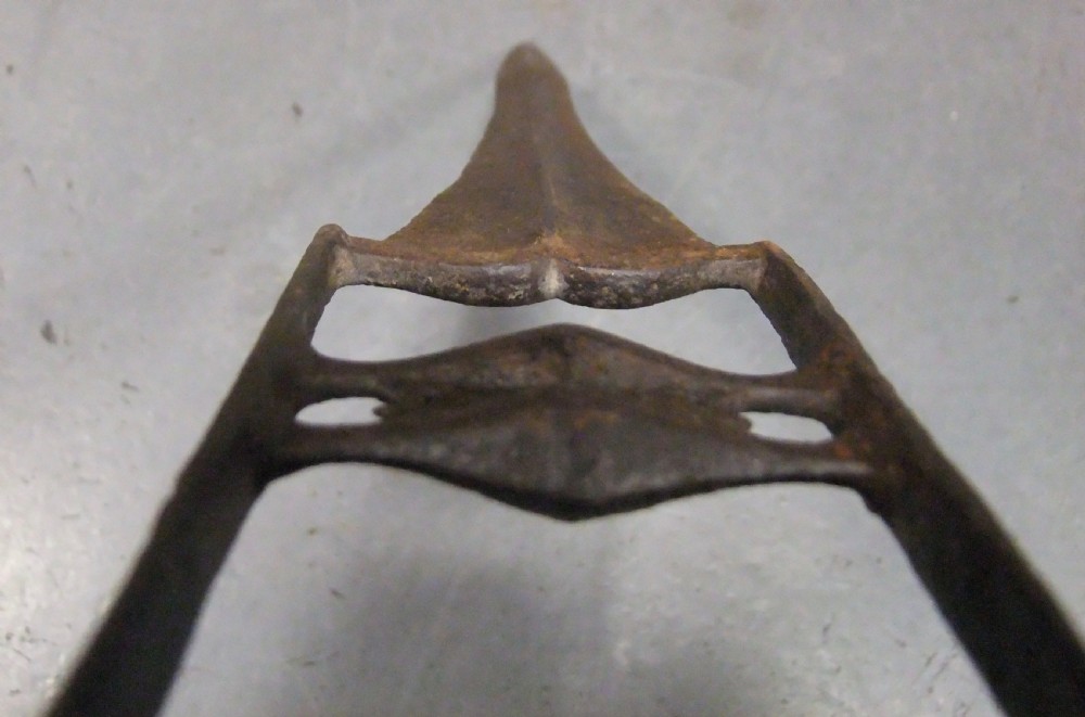 An antique Indian Katar push dagger featuring a dark iron H-shaped handle with double crossbars beside its tapered leather scabbard. View X