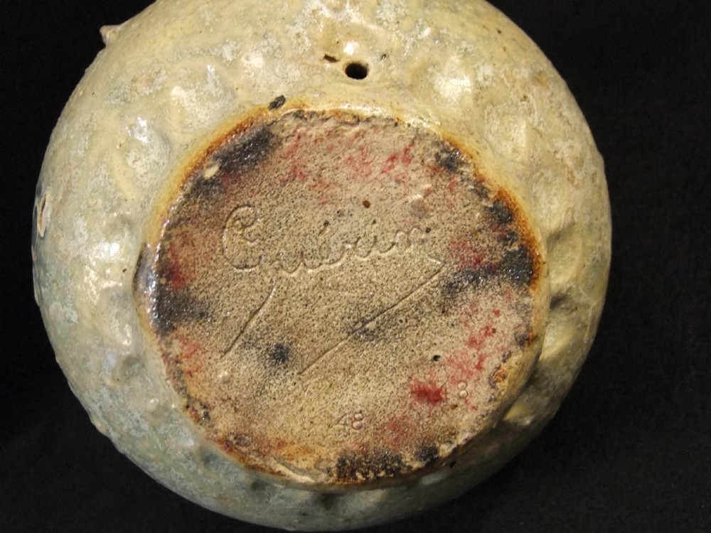 A rounded salt-glazed stoneware flask featuring two top loop handles and a central circular heraldic medallion in neutral grey and beige tones. View VI