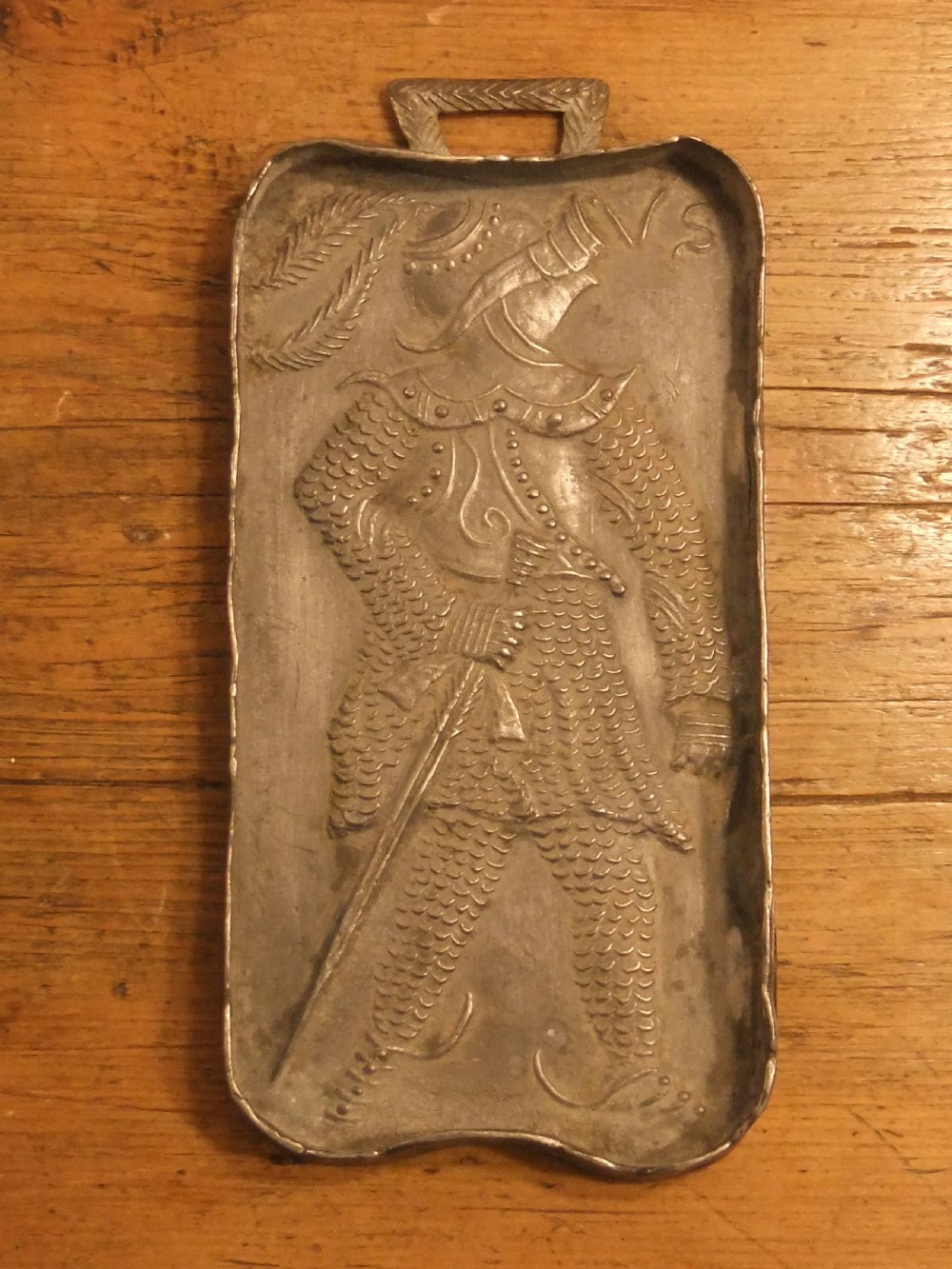 A grey lead alloy hinged diptych panel featuring a crude relief casting of a haloed figure holding a key alongside a companion panel with pseudo-medieval inscriptions. View X