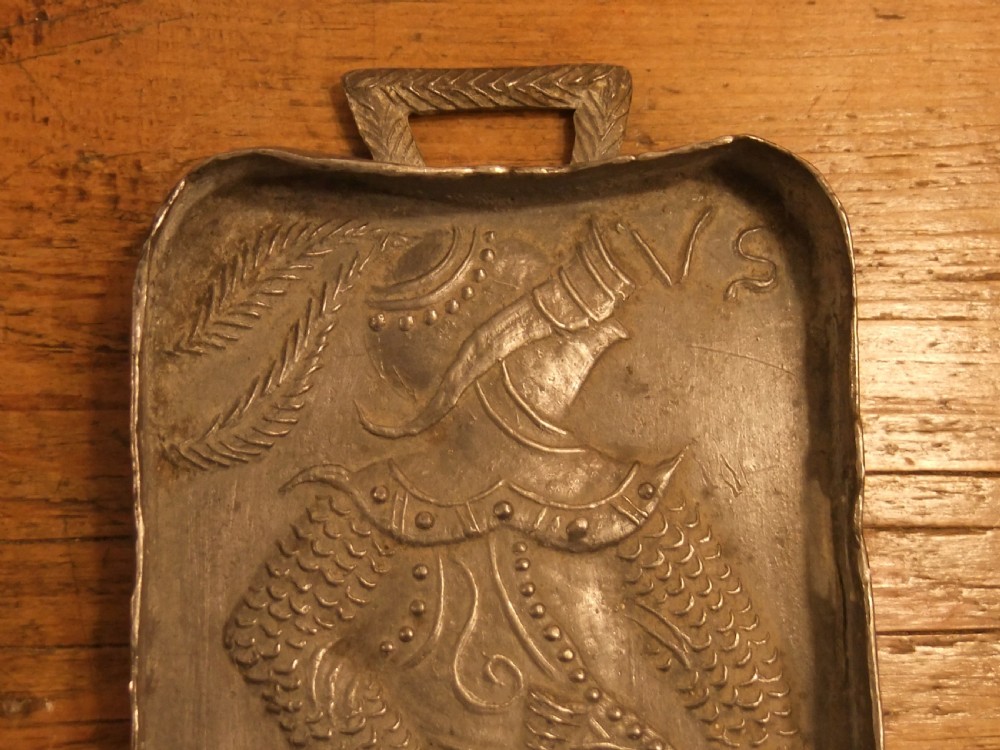 A grey lead alloy hinged diptych panel featuring a crude relief casting of a haloed figure holding a key alongside a companion panel with pseudo-medieval inscriptions. View XI
