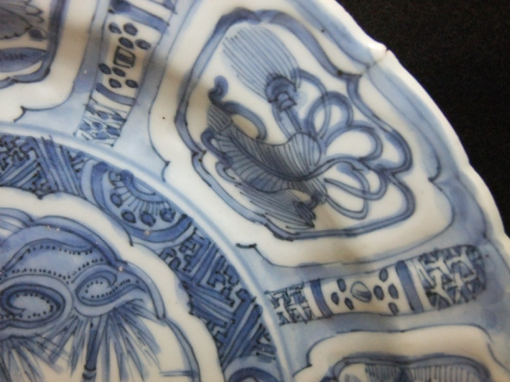 A Chinese Wanli Kraak porcelain deep plate decorated in underglaze blue with central birds and plants surrounded by a panelled rim with a scalloped edge. View III
