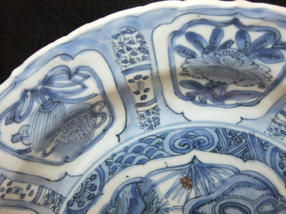 A Chinese Wanli Kraak porcelain deep plate decorated in underglaze blue with central birds and plants surrounded by a panelled rim with a scalloped edge. View IV