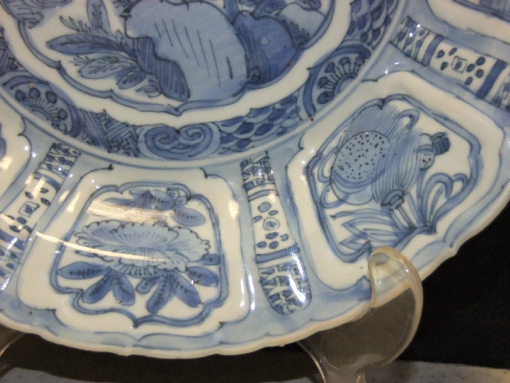 A Chinese Wanli Kraak porcelain deep plate decorated in underglaze blue with central birds and plants surrounded by a panelled rim with a scalloped edge. View VI