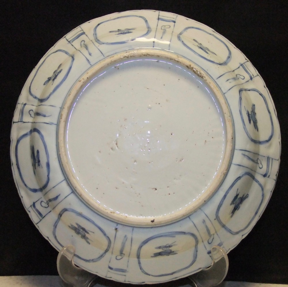 A Chinese Wanli Kraak porcelain deep plate decorated in underglaze blue with central birds and plants surrounded by a panelled rim with a scalloped edge. View VII