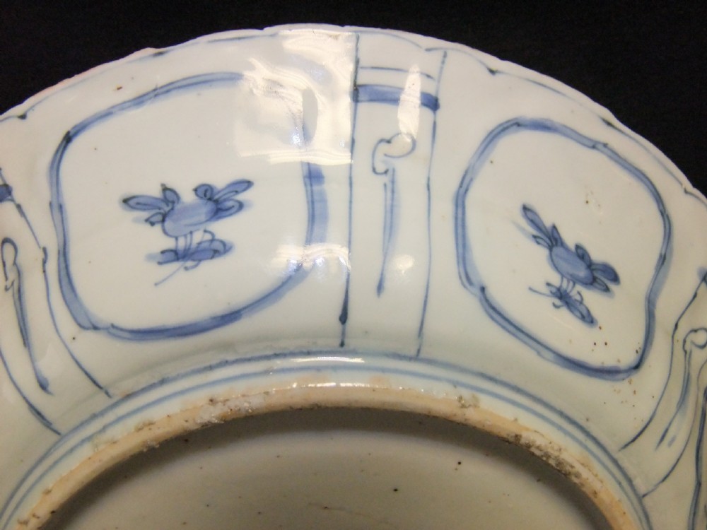 A Chinese Wanli Kraak porcelain deep plate decorated in underglaze blue with central birds and plants surrounded by a panelled rim with a scalloped edge. View IX