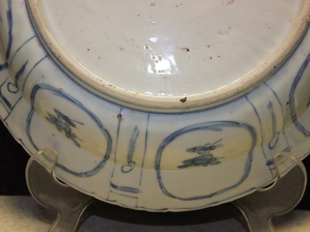 A Chinese Wanli Kraak porcelain deep plate decorated in underglaze blue with central birds and plants surrounded by a panelled rim with a scalloped edge. View XII