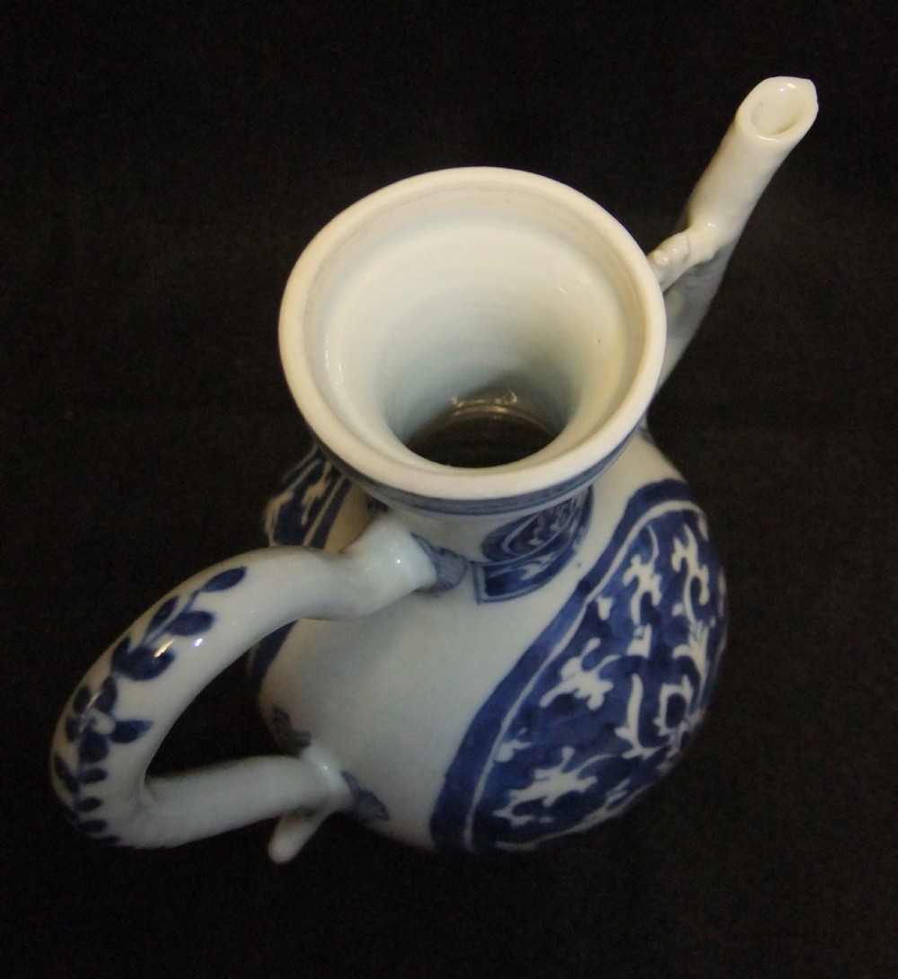 A blue and white Chinese porcelain wine ewer featuring an elongated curved handle, a tall spout with a connecting strut, and painted floral medallion motifs. View VIII