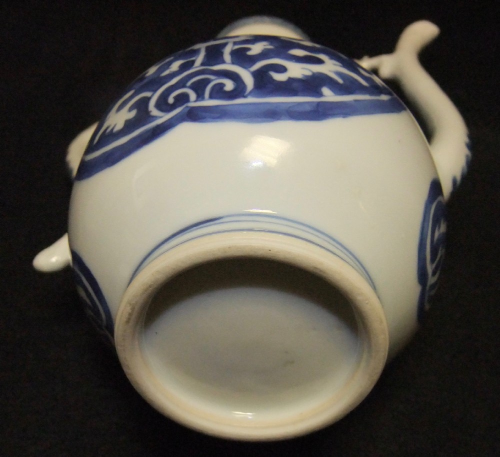 A blue and white Chinese porcelain wine ewer featuring an elongated curved handle, a tall spout with a connecting strut, and painted floral medallion motifs. View IX