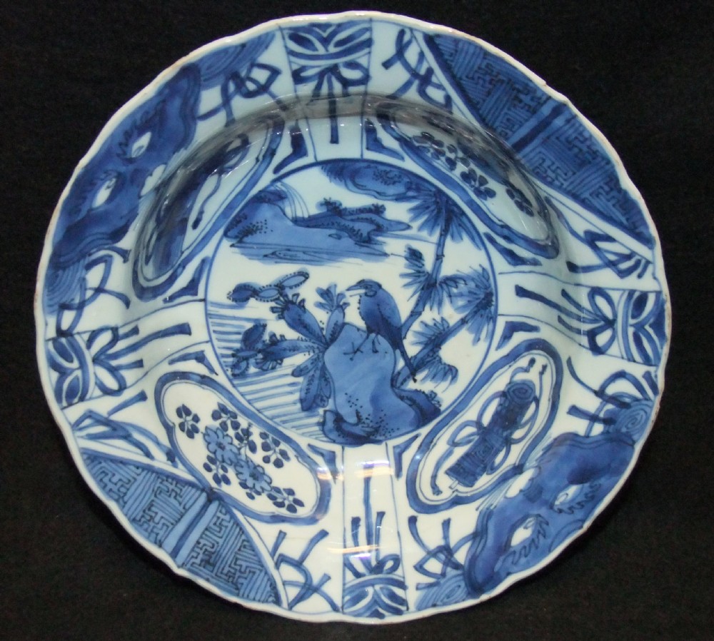 A circular Wanli period Kraak porcelain klapmuts bowl decorated with cobalt blue underglaze landscapes and panelled rim motifs.