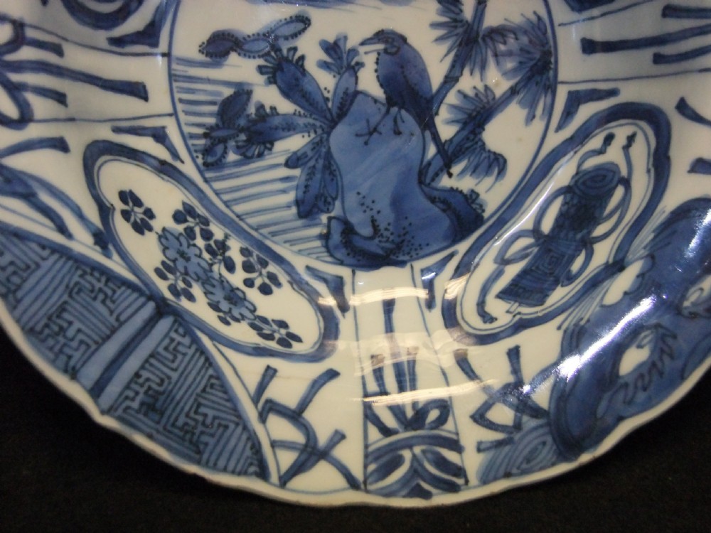A circular Wanli period Kraak porcelain klapmuts bowl decorated with cobalt blue underglaze landscapes and panelled rim motifs. View IV