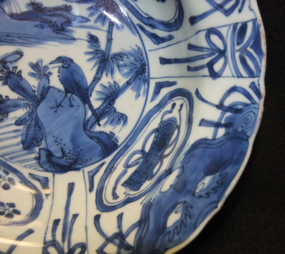 A circular Wanli period Kraak porcelain klapmuts bowl decorated with cobalt blue underglaze landscapes and panelled rim motifs. View IX
