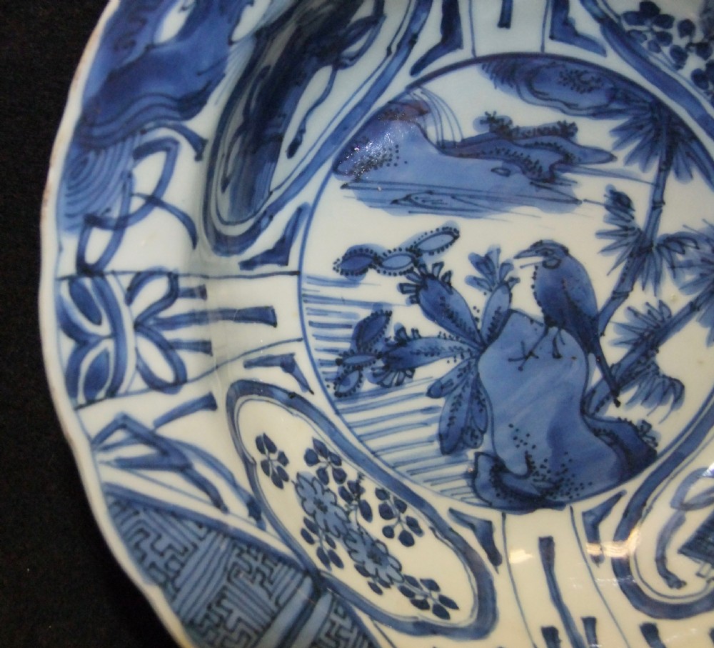 A circular Wanli period Kraak porcelain klapmuts bowl decorated with cobalt blue underglaze landscapes and panelled rim motifs. View XI