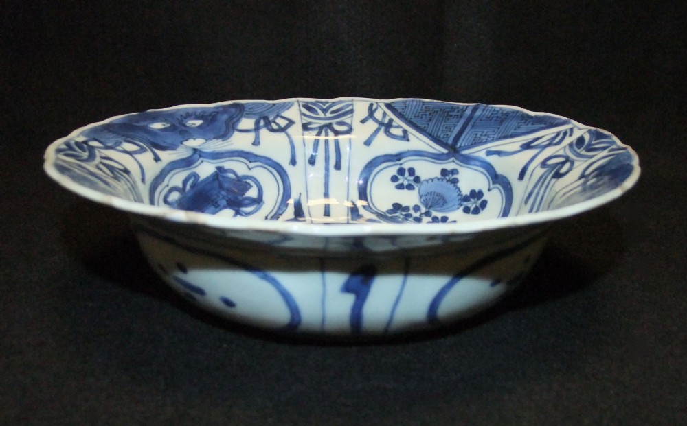 A circular Wanli period Kraak porcelain klapmuts bowl decorated with cobalt blue underglaze landscapes and panelled rim motifs. View XII