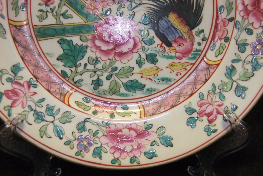 A pair of circular Chinese export porcelain plates decorated with hand-painted roosters, peonies, and pink and green floral borders. View VI