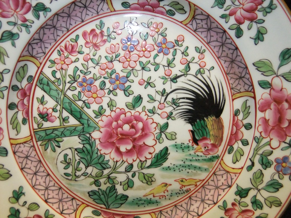 A pair of circular Chinese export porcelain plates decorated with hand-painted roosters, peonies, and pink and green floral borders. View X