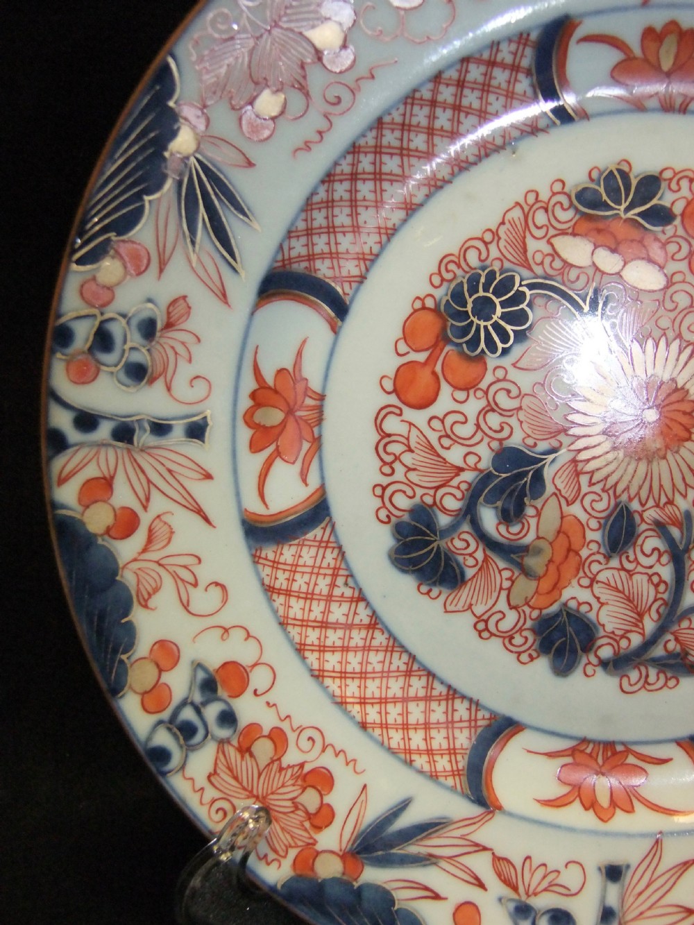 A pair of circular Japanese Edo Period Imari porcelain plates featuring intricate floral motifs in underglaze blue, iron red, and gold gilding on a white ground. View VII