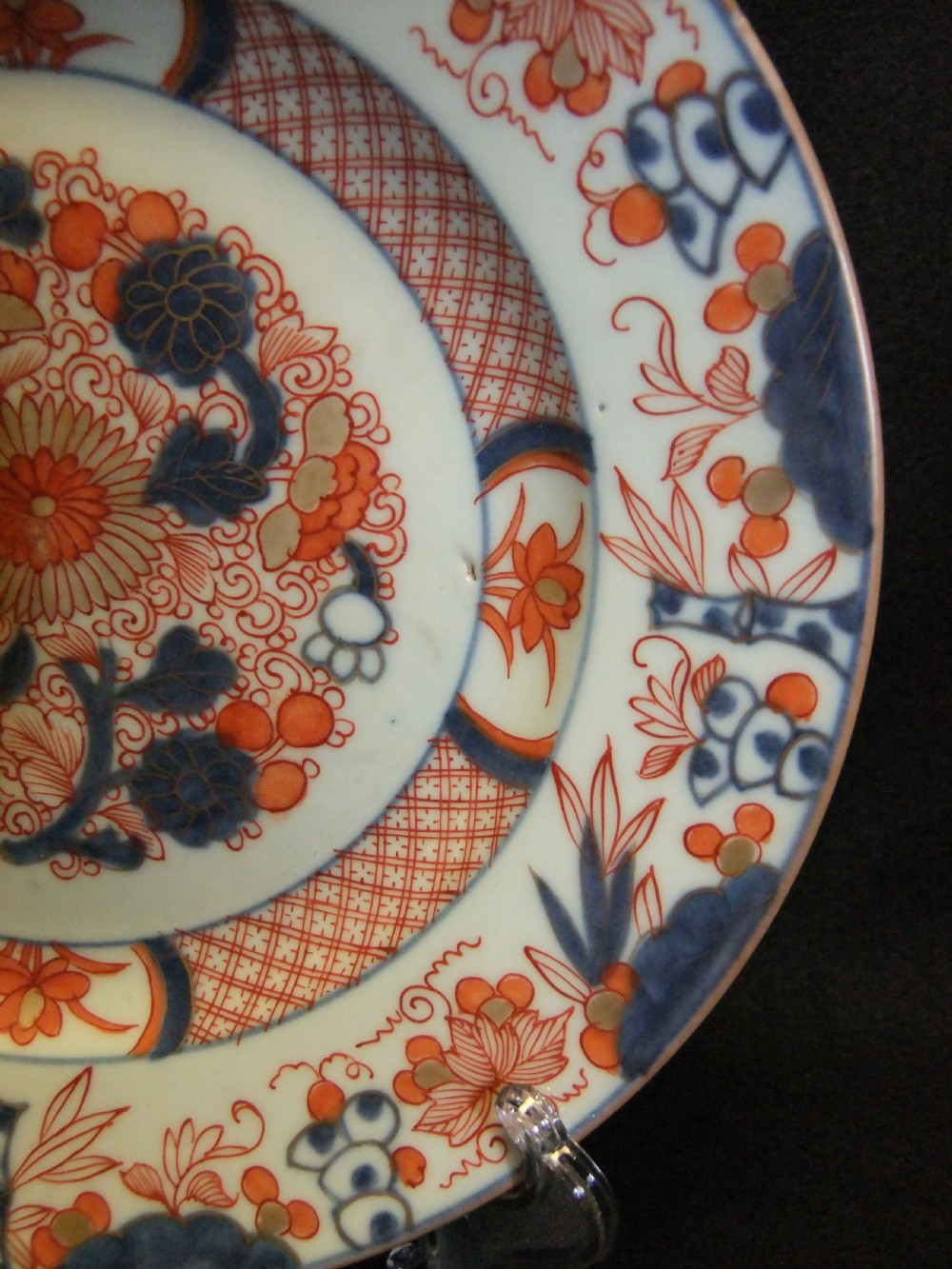 A pair of circular Japanese Edo Period Imari porcelain plates featuring intricate floral motifs in underglaze blue, iron red, and gold gilding on a white ground. View XII