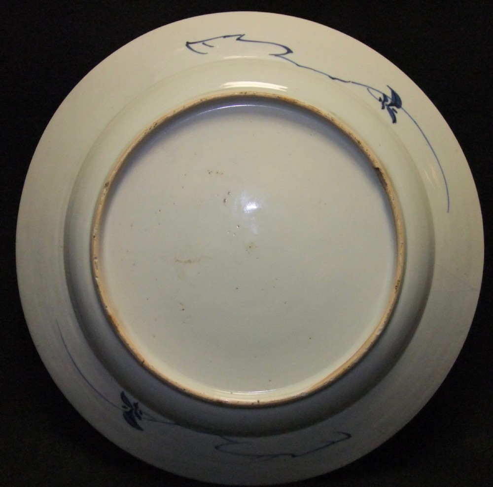 A circular Chinese Kangxi period blue and white porcelain charger featuring hand-painted birds on rockwork surrounded by flowering prunus branches and a decorative panelled border. View VII