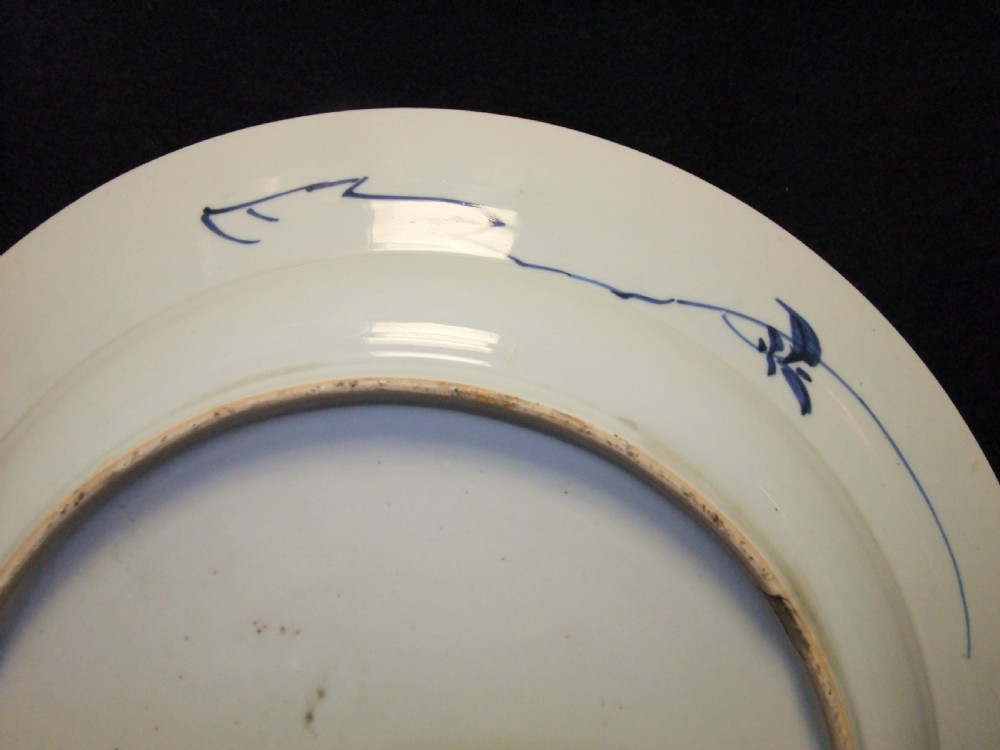 A circular Chinese Kangxi period blue and white porcelain charger featuring hand-painted birds on rockwork surrounded by flowering prunus branches and a decorative panelled border. View VIII