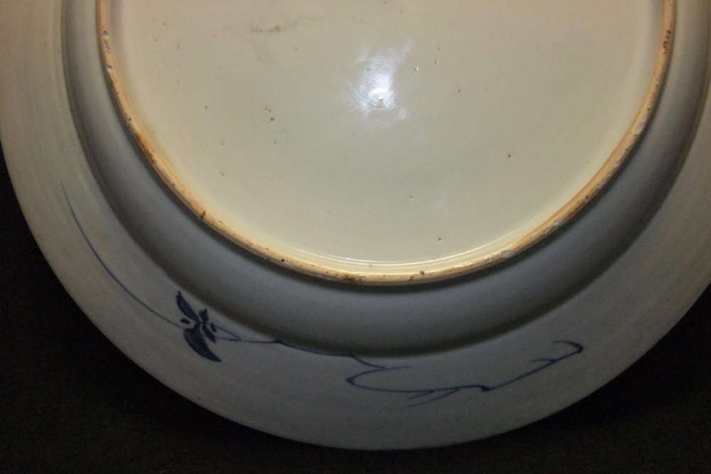 A circular Chinese Kangxi period blue and white porcelain charger featuring hand-painted birds on rockwork surrounded by flowering prunus branches and a decorative panelled border. View X
