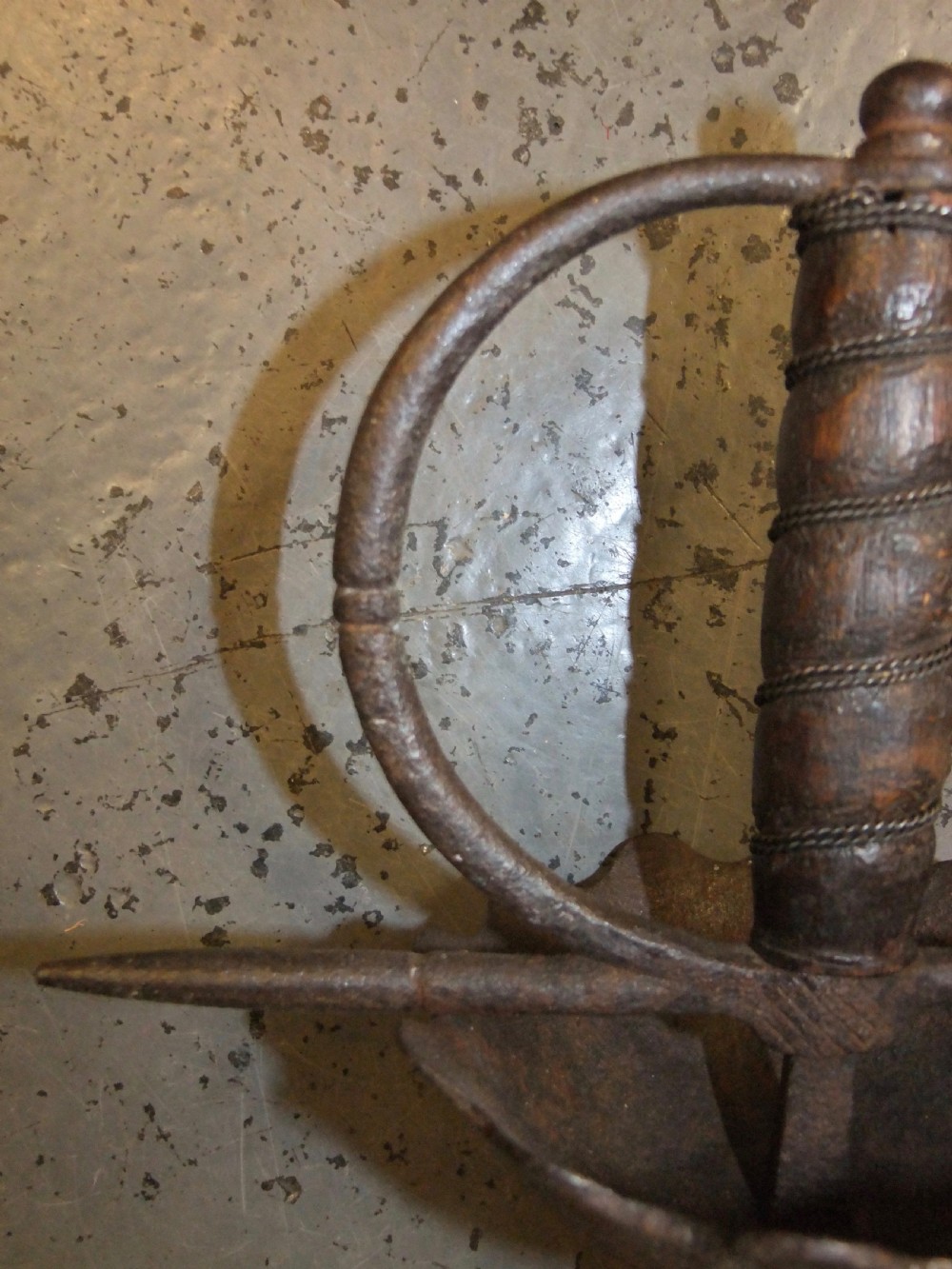 A 17th-century steel cup-hilt sword featuring a long wavy flamberge blade and a rounded metal hand guard. View VI