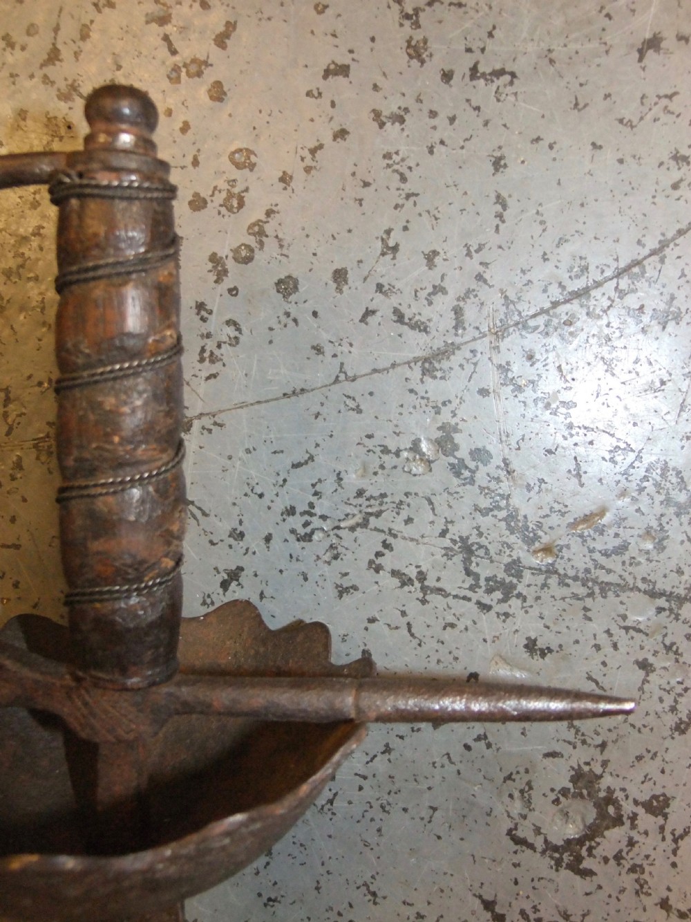 A 17th-century steel cup-hilt sword featuring a long wavy flamberge blade and a rounded metal hand guard. View VII