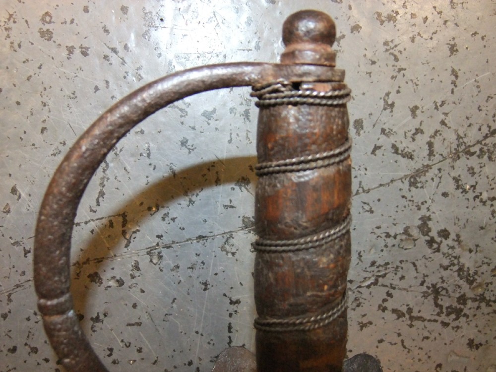 A 17th-century steel cup-hilt sword featuring a long wavy flamberge blade and a rounded metal hand guard. View XXII