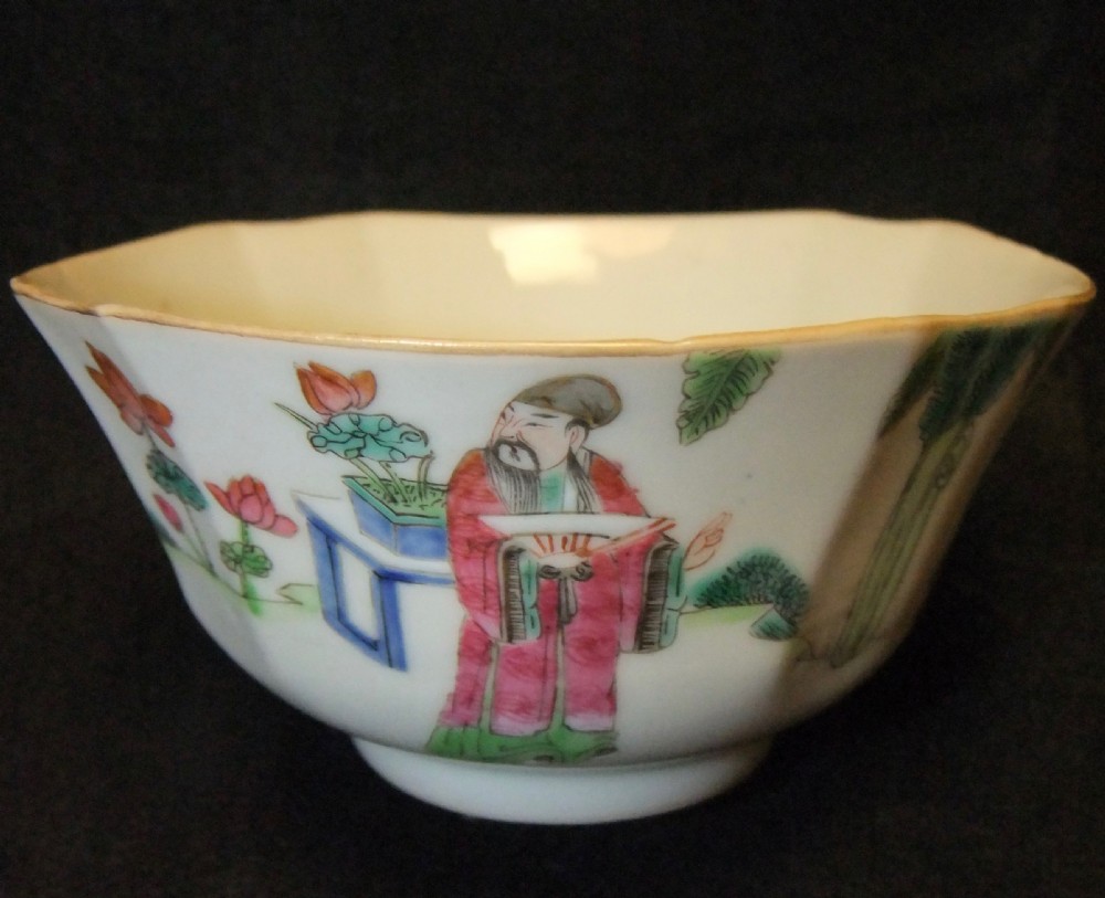 An octagonal Chinese white porcelain bowl decorated with hand-painted famille rose enamels featuring a figure in pink robes and lotus blossoms.