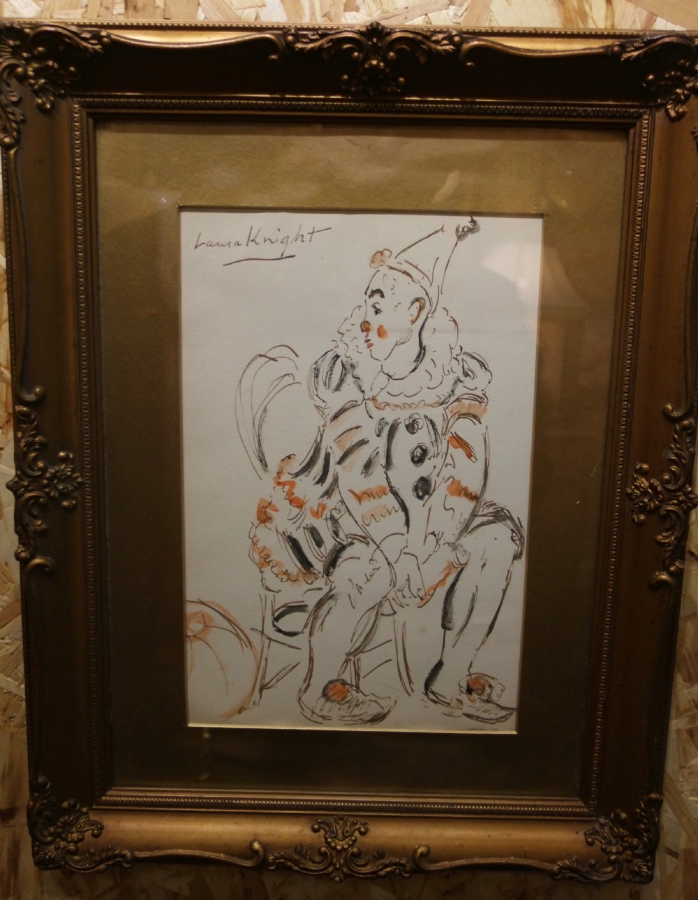 An ink and watercolour sketch depicting a seated clown in costume, signed Laura Knight in the upper left corner. View IV