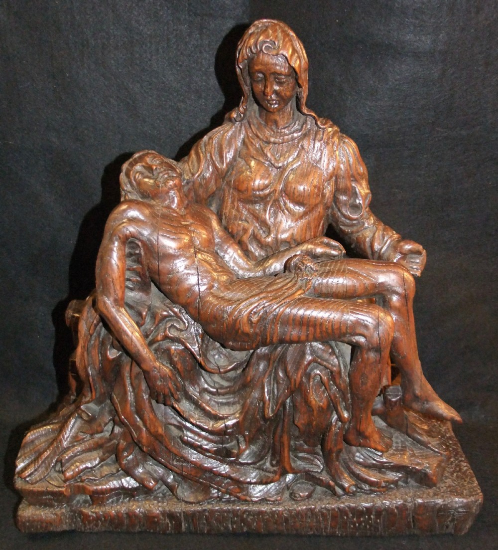A medieval hand-carved oak sculpture depicting the Virgin Mary cradling the body of Christ.
