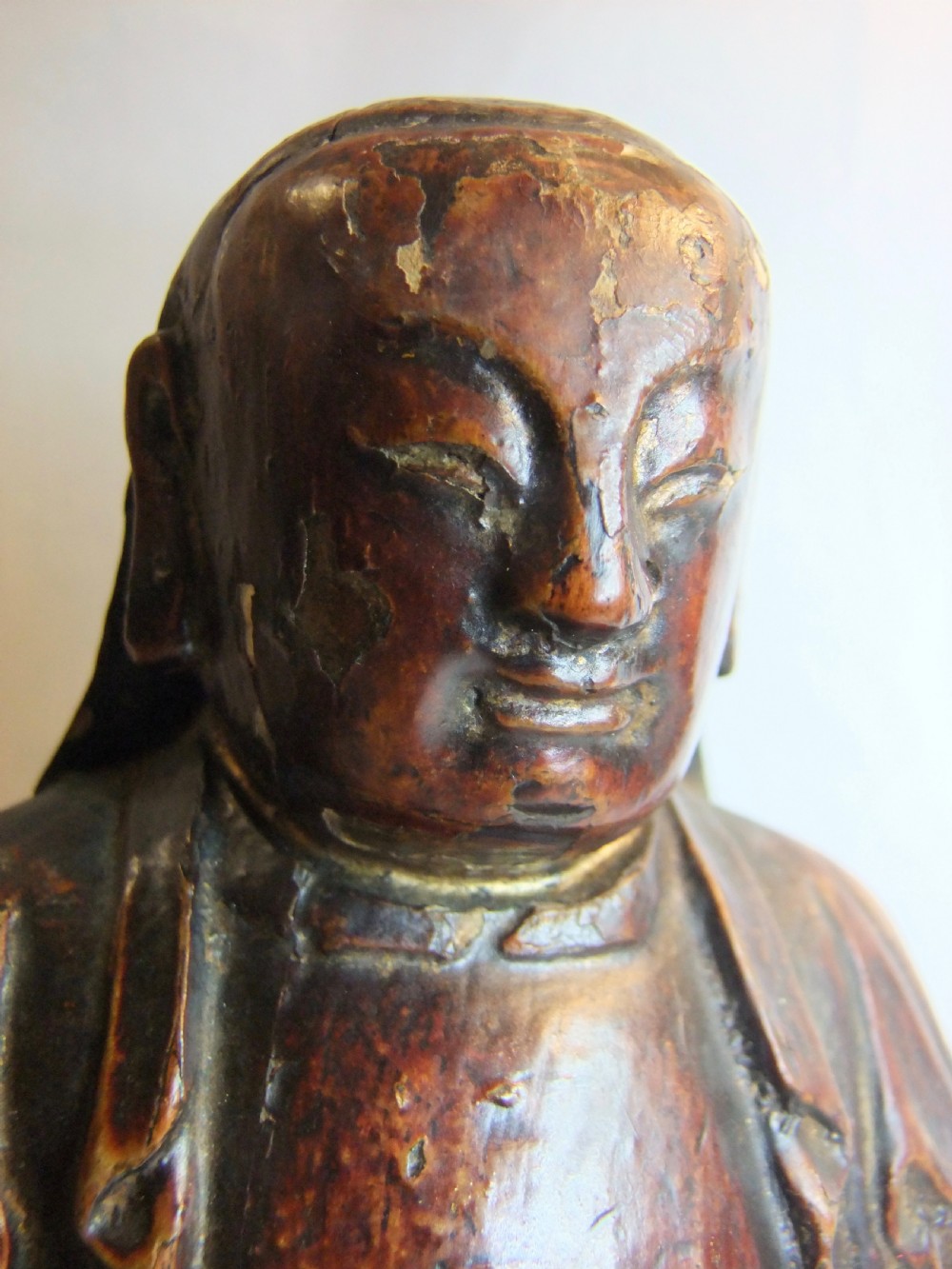 An antique Chinese hand-carved dark wood statue depicting a seated figure in traditional Qing Dynasty robes with traces of gilding and red lacquer. View III