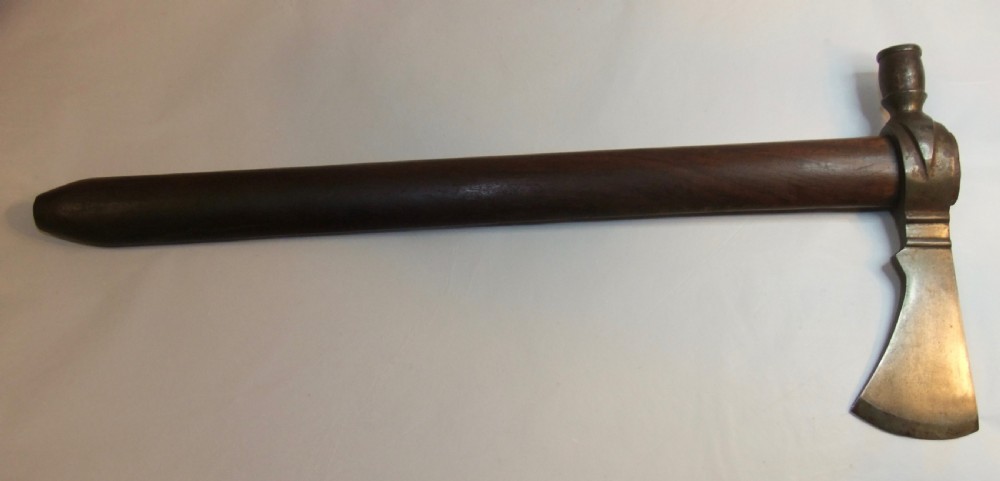 A 19th-century Dakota Sioux pipe tomahawk featuring a forged iron axe head with an integrated pipe bowl mounted on a dark wooden haft. View II