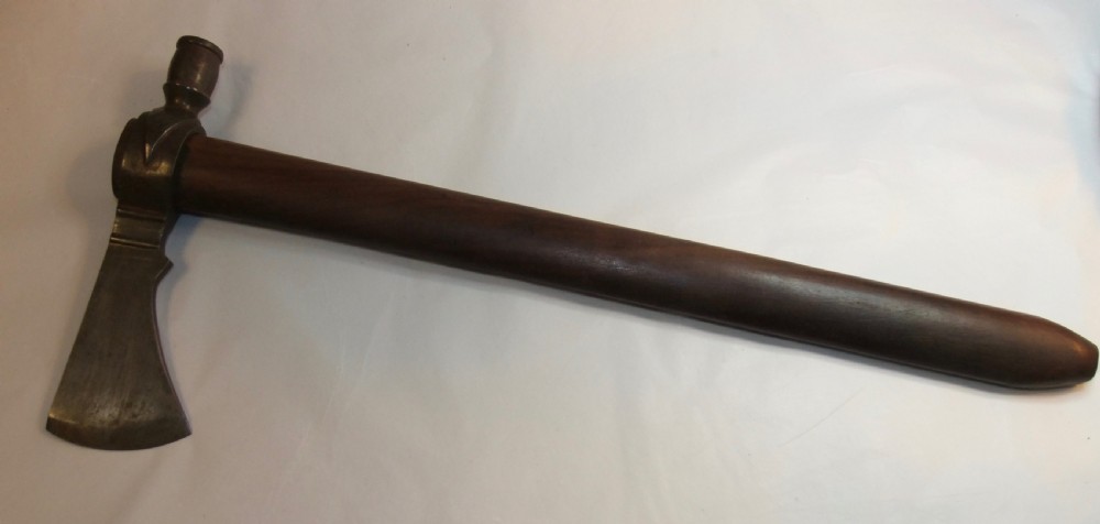 A 19th-century Dakota Sioux pipe tomahawk featuring a forged iron axe head with an integrated pipe bowl mounted on a dark wooden haft. View III