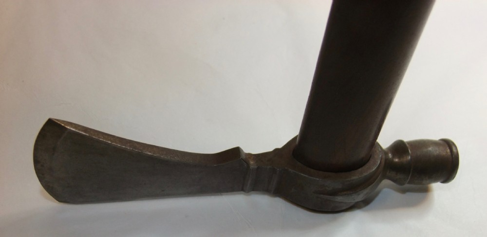 A 19th-century Dakota Sioux pipe tomahawk featuring a forged iron axe head with an integrated pipe bowl mounted on a dark wooden haft. View VII