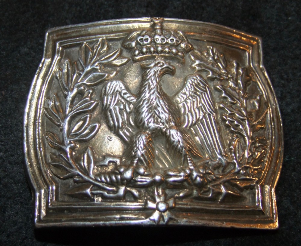 A French Empire period solid silver gilt waist belt clasp featuring a raised relief of a crowned eagle holding thunderbolts, surrounded by laurel and oak wreaths.