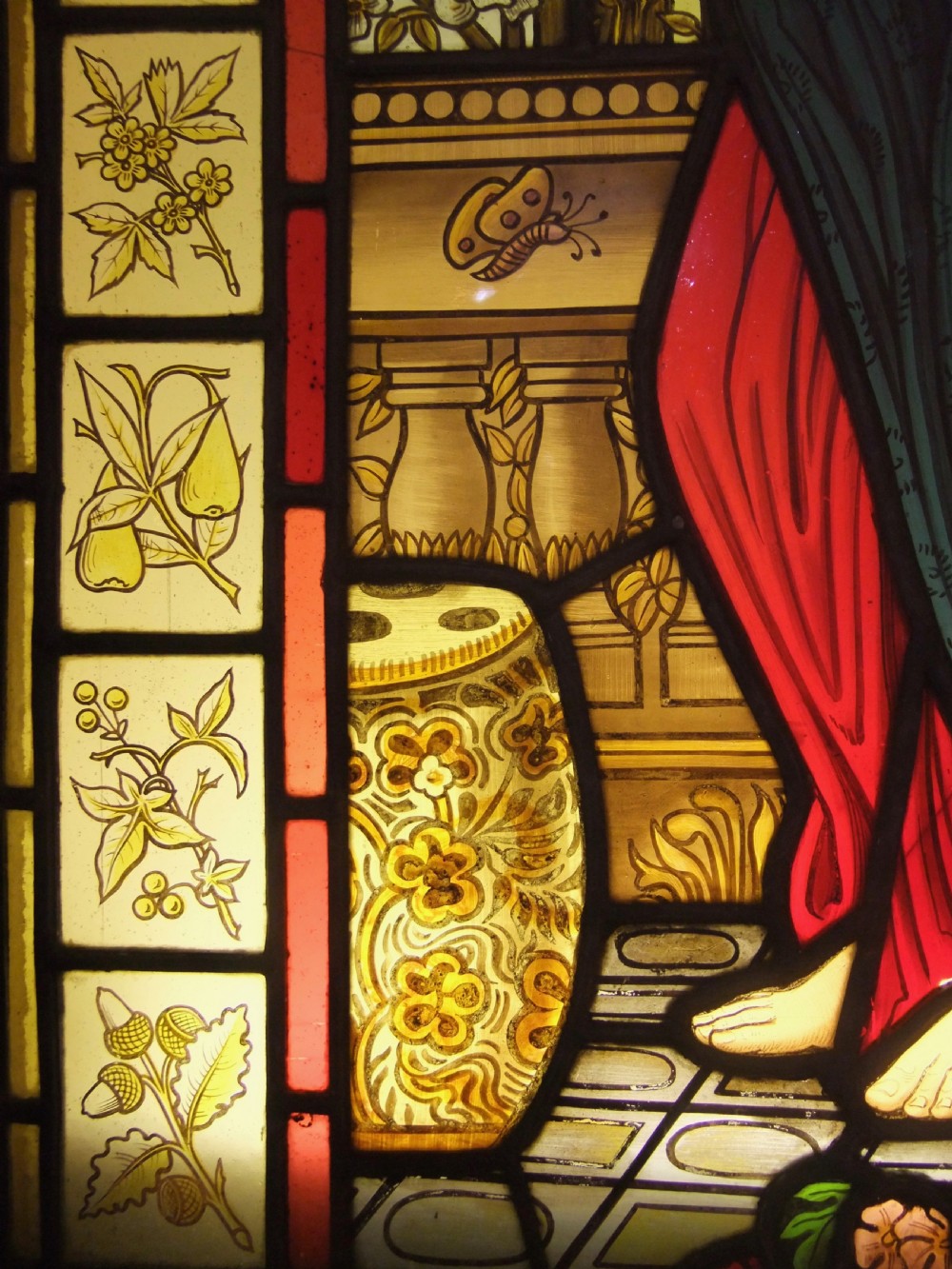 A Pre-Raphaelite stained glass panel featuring a draped female figure surrounded by blossoms and framed by botanical pattern tiles. View IV
