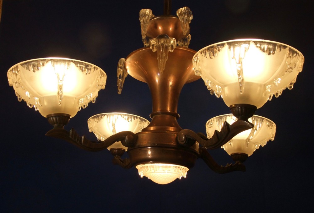 An Art Deco copper chandelier featuring a flared central stem, decorative glass icicle motifs, and four frosted glass shades fitted with light bulbs. View III