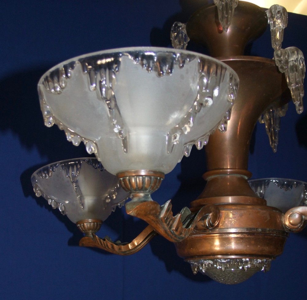 An Art Deco copper chandelier featuring a flared central stem, decorative glass icicle motifs, and four frosted glass shades fitted with light bulbs. View VIII
