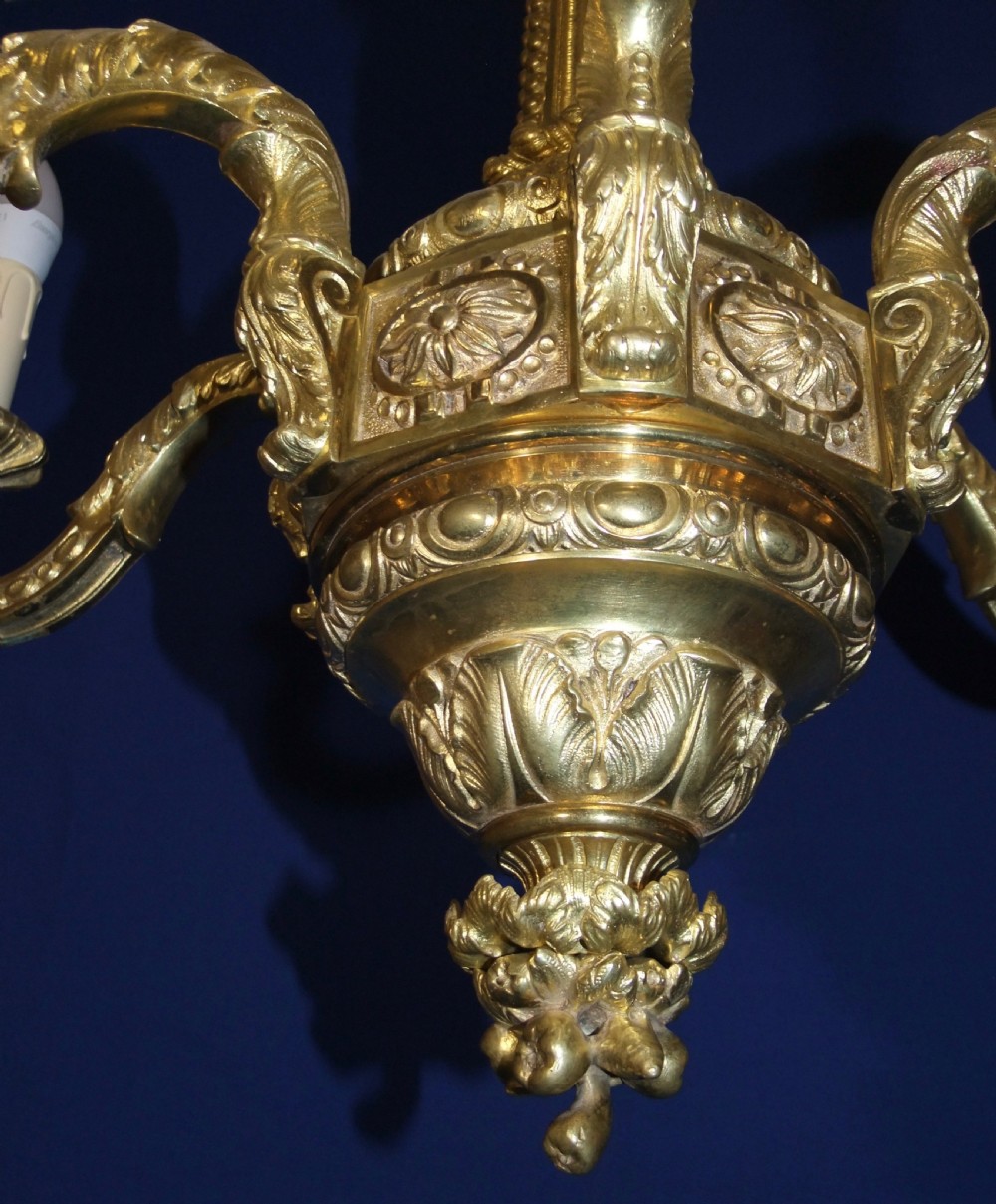 A six-arm gilt bronze chandelier in the Baroque style featuring scrolling arms, acanthus leaf detailing, and candle-style bulb sleeves. View VIII