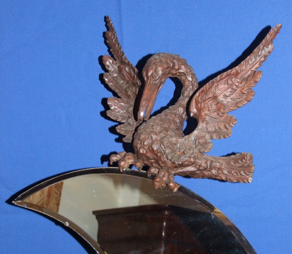 A late 19th-century carved wood mirror featuring a crescent moon-shaped glass surrounded by detailed carvings of wading birds and reeds. View III