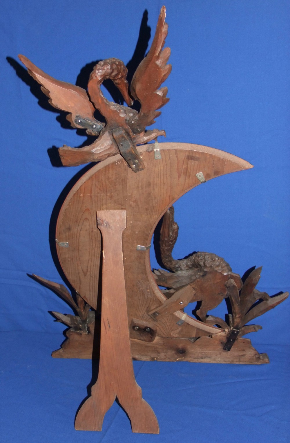 A late 19th-century carved wood mirror featuring a crescent moon-shaped glass surrounded by detailed carvings of wading birds and reeds. View VI