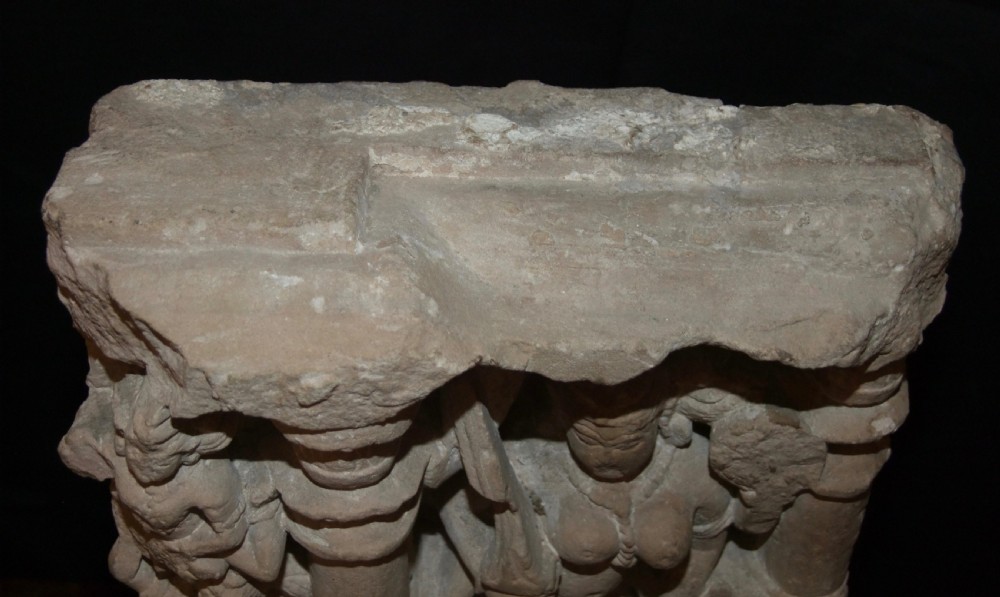 A carved beige sandstone relief fragment from 11th century India depicting the Hindu deity Parvati flanked by decorative columns and smaller attendant figures. View X