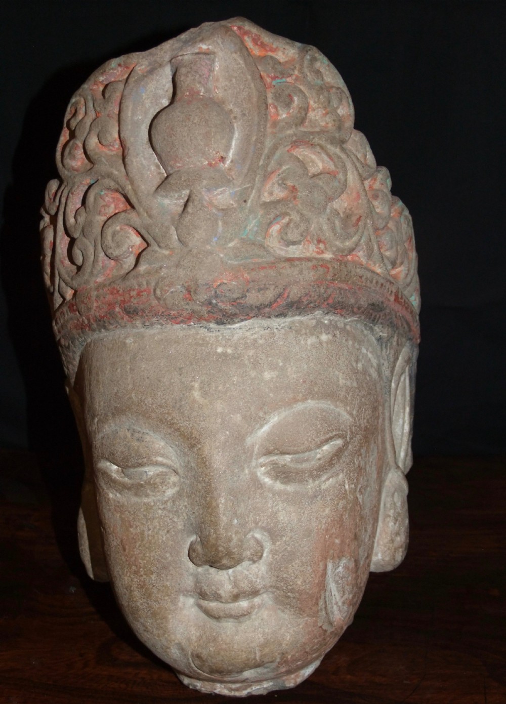 Carved sandstone head of Avalokiteshvara featuring an elaborate crown, gentle facial contours, and visible traces of red and green pigment. View II
