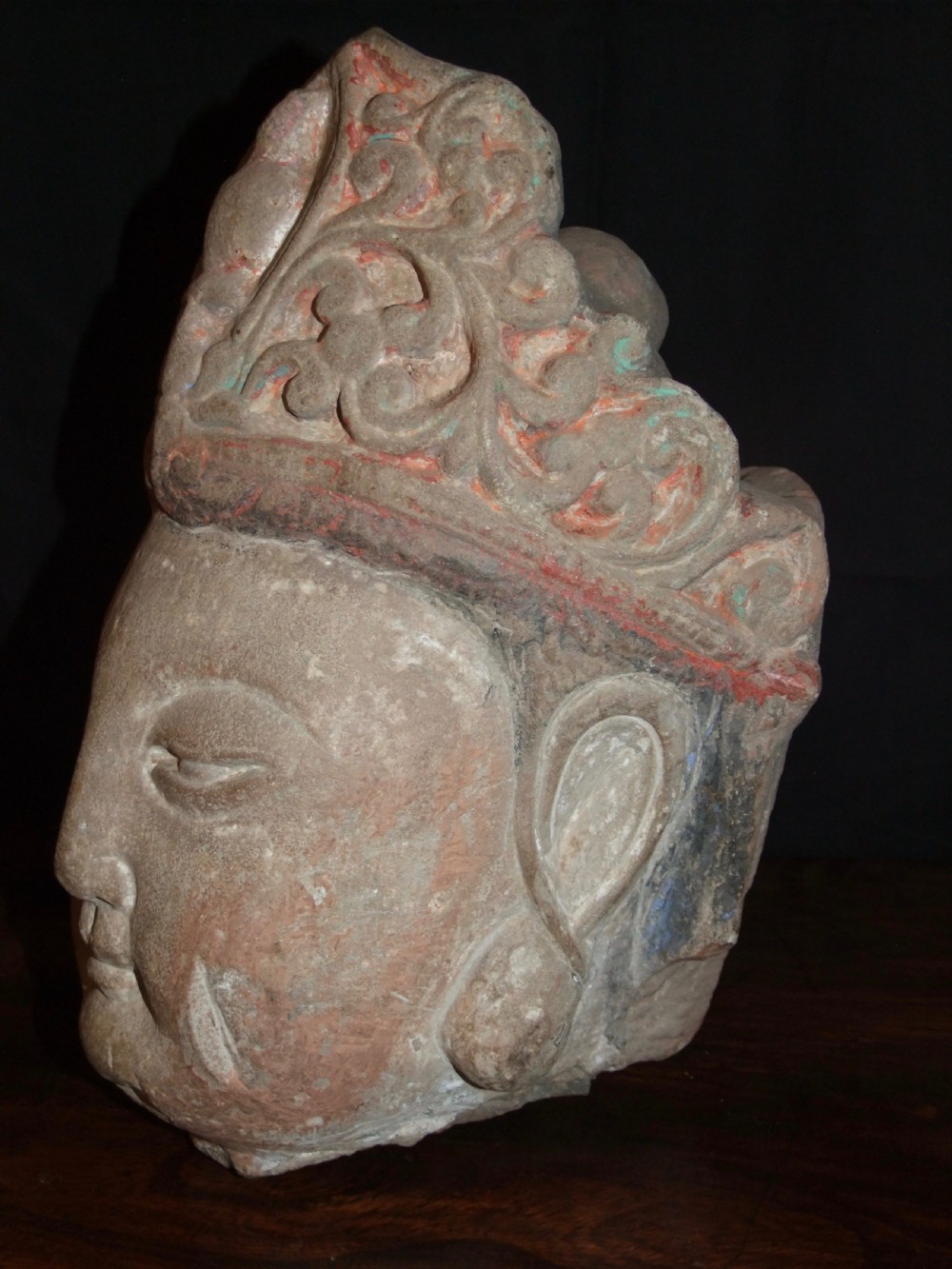Carved sandstone head of Avalokiteshvara featuring an elaborate crown, gentle facial contours, and visible traces of red and green pigment. View III